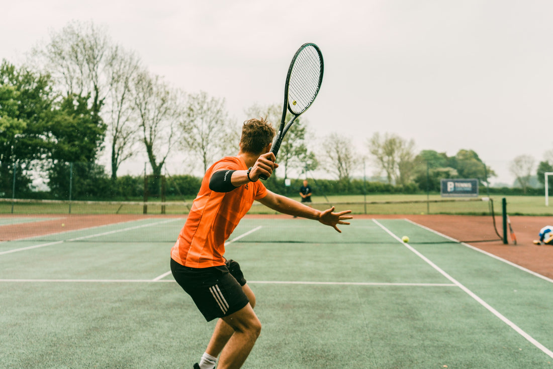 man playing tennis at a local park