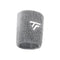 The Tecnifibre Tennis Wristband Sweatband XL - Silver is a gray wristband with a textured fabric design, featuring a white embroidered logo of two intersecting lines forming a stylized letter "T." It is super absorbent, making it perfect for intense matches.