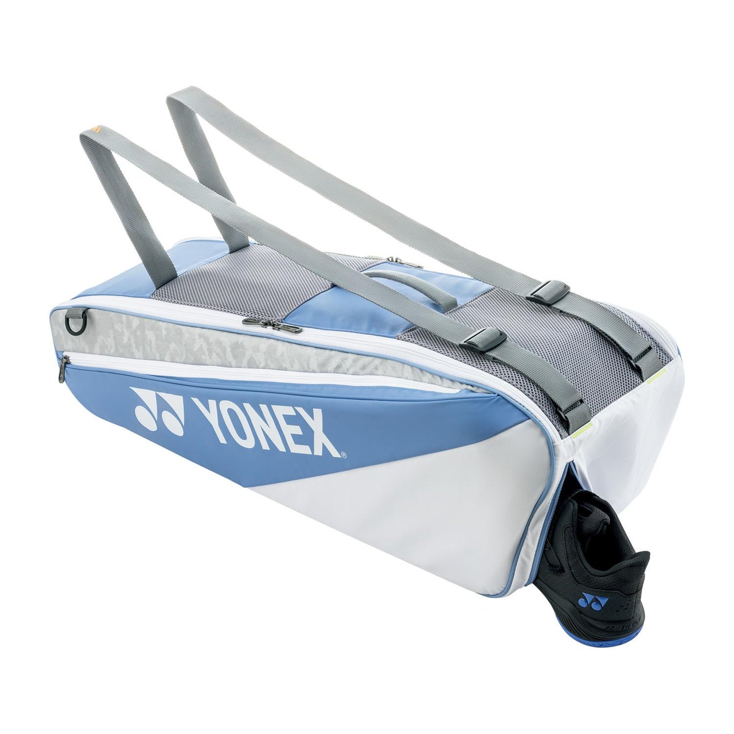 A greyish blue Yonex 52526EX Club 6 Racket Tennis Bag with two shoulder straps is depicted. It accommodates up to 6 rackets, and a black and blue shoe is partially inserted in a side compartment.