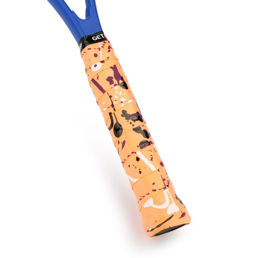 A close-up of a tennis racket handle showcases the Get A Grip Hot Mess Tennis Overgrip - Orange by Get A Grip, featuring a premium camo print grip in vibrant shades of orange, black, and purple. The non-slip top edge is blue with the word "GET" prominently displayed. This modern and artistic overgrip design ensures optimal performance on the court.