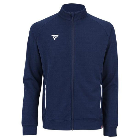 The Tecnifibre Men's Team Tennis Jacket in Marine is a lightweight zip-up with navy blue coloring and white zipper accents on the pockets. It features a breathable design, high collar, and a small white logo on the upper chest.