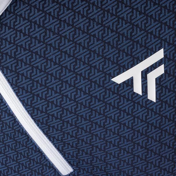 Close-up of a textured, stretchy knit fabric featuring a blue geometric pattern and the white stylized logo of Tecnifibre. A Thermo Zipper from the Tecnifibre Mens Thermo Tennis Zipper Longsleeve - White runs diagonally across the lower left corner.