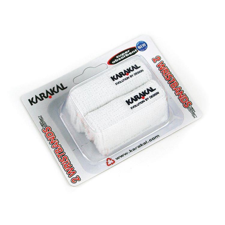 A twin pack featuring two ultra-absorbent white Karakal Tennis Wrist Bands is presented in packaging labeled "Karakal Tennis Wrist Band (Twin Pack) - White," highlighting the Karakal brand in black and red text with an added embroidered logo for style.