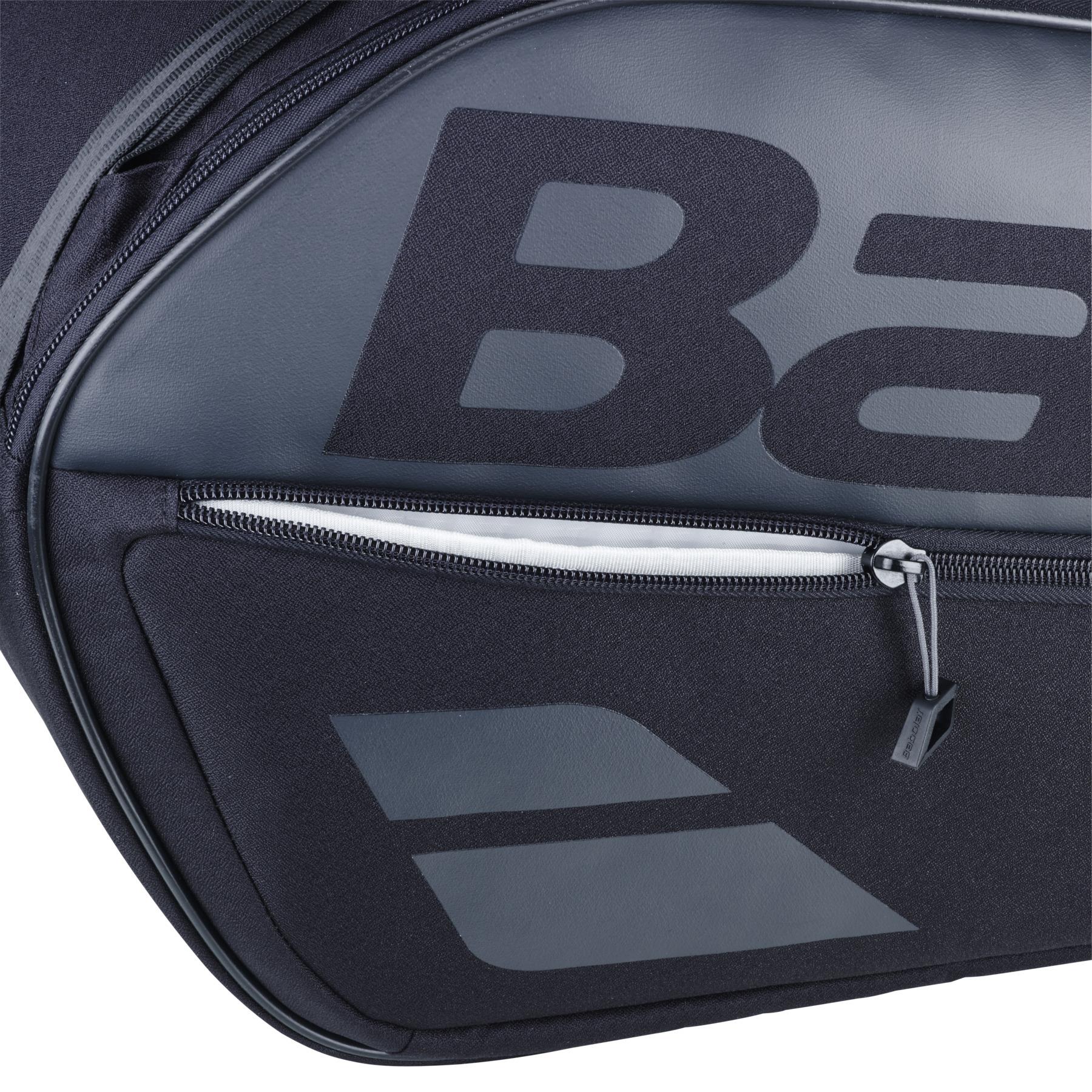 Close-up of the black Babolat Court L 9 Racket Tennis Bag, highlighting a large, partially visible logo. The bag features a zippered pocket with a gray pull and boasts a stylish corner design element, showcasing its versatility for all your tennis needs.