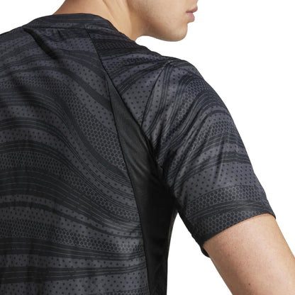 A person sports the ADIDAS Men's Club Graphic Tennis T-Shirt in black, featuring short sleeves and a stylish dotted, wavy pattern in grays and blacks. Made from recycled materials, this shirt highlights the upper back and shoulder against a white background.