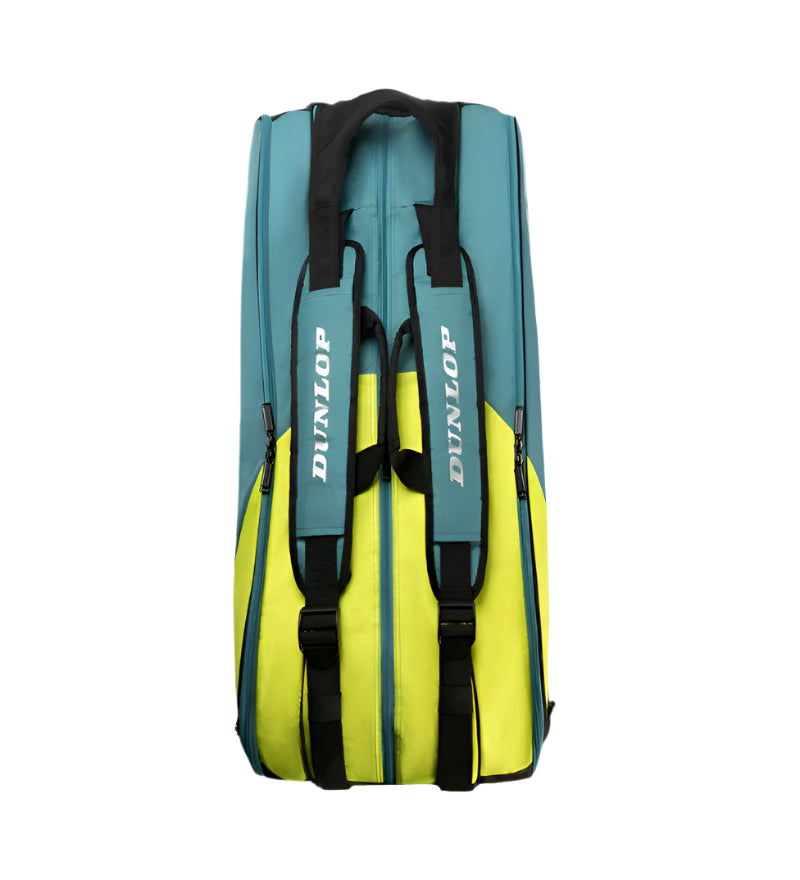 The Dunlop SX Performance 12 Racket Tennis Bag in teal, black, and yellow stands upright with ergonomic padded shoulder straps. It features multiple zippers in a sleek rectangular design, with "Dunlop" prominently displayed on the straps.