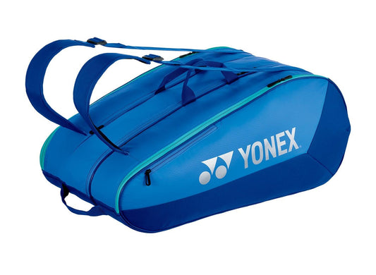 The Yonex 425212EX Team 12 Racket Tennis Bag in Blast Blue features two shoulder straps, three zippered compartments, and the brand logo and name printed in white on the side—ideal for carrying your gear.