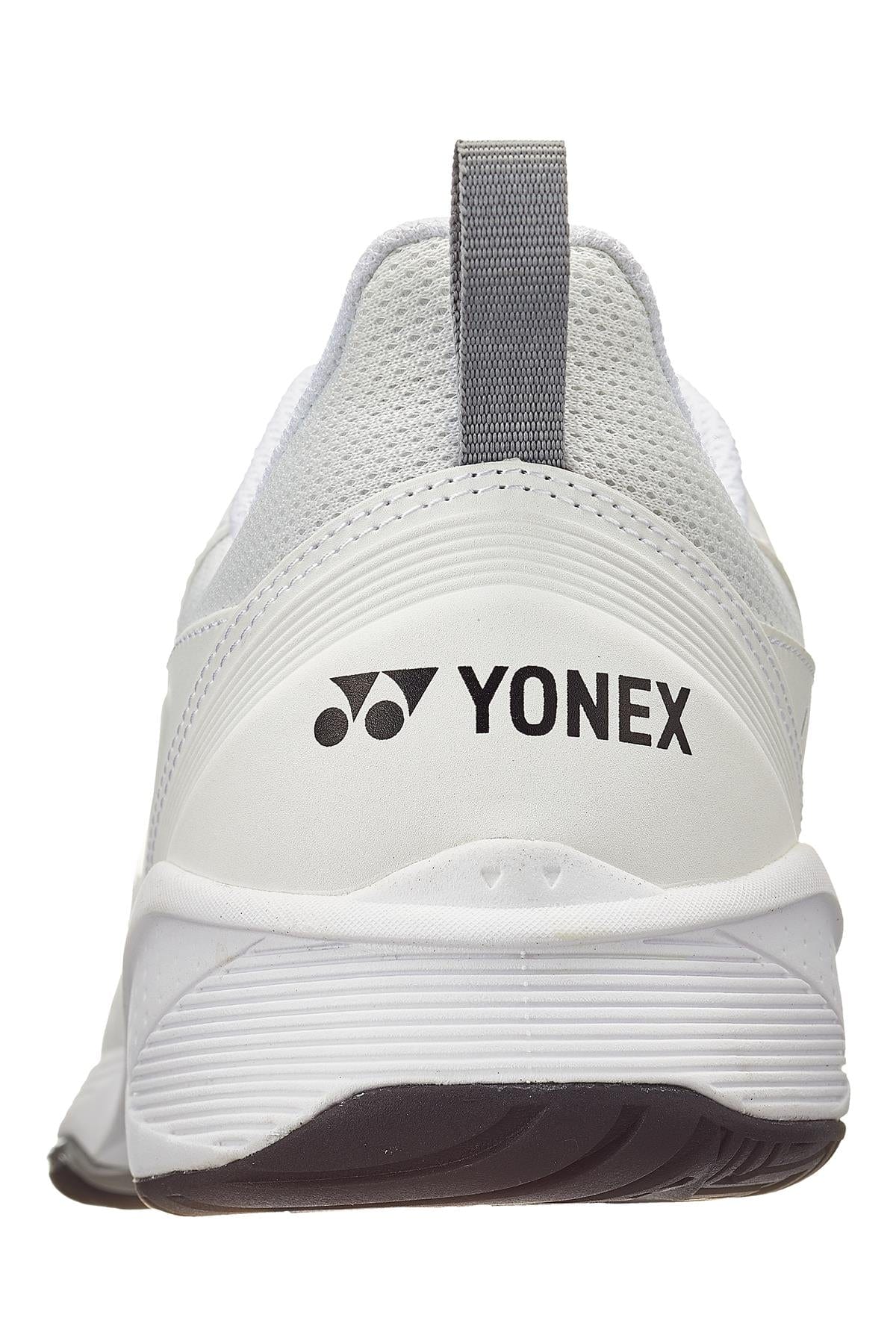 The Yonex Power Cushion Sonicage 3 Wide Men's Tennis Shoes in White/Black feature a rear view highlighting the sleek design with a gray pull tab and black outsole. The bold black Yonex Power Cushion logo is prominently displayed on the heel, combining comfort with style.